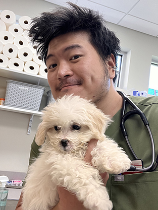 student holding white dog